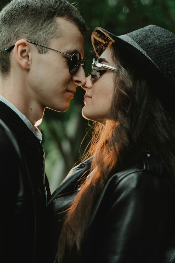 Stylish couple in sunglasses rubbing noses